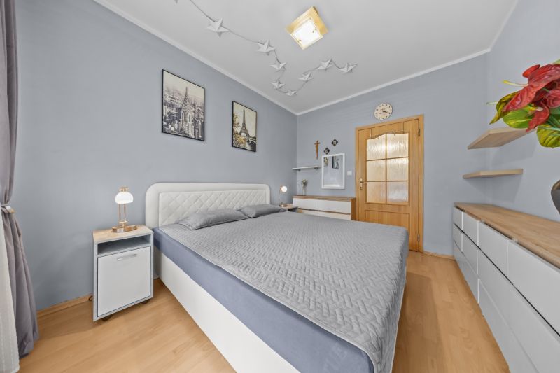 Bedroom in a 3-room apartment with wall decorations and a wooden decor floor.