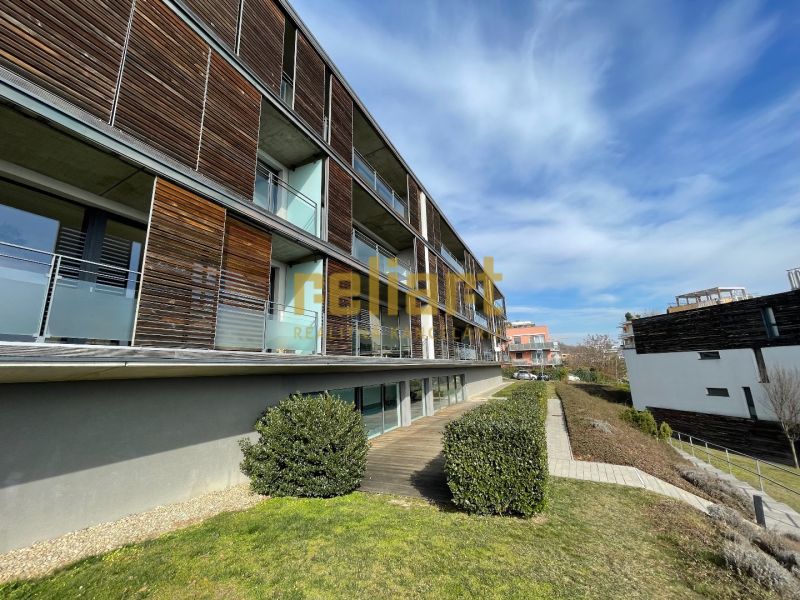 An apartment building with wooden elements and a garden in Bratislava - Nové Mesto on Na Zlatej nohe Street.