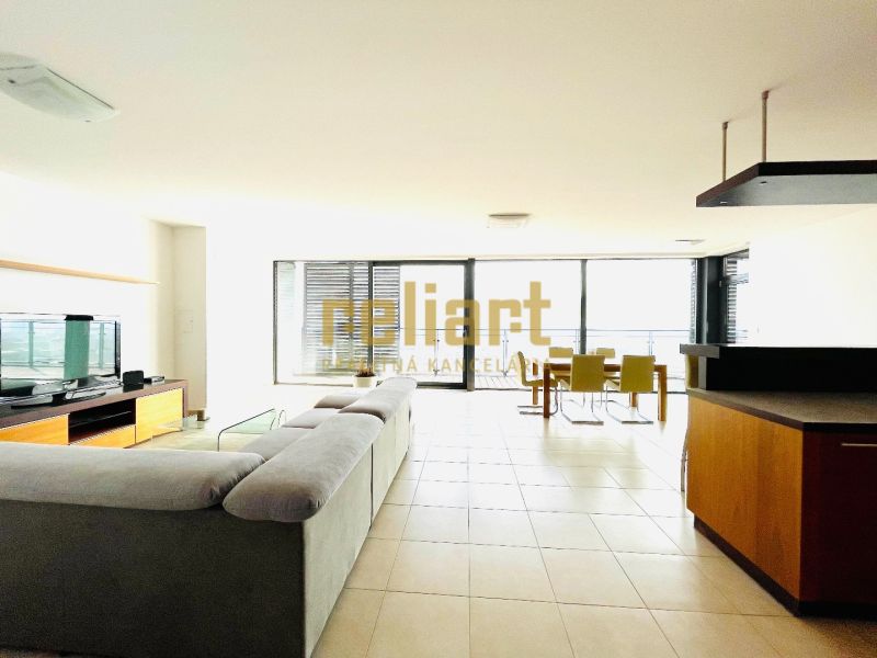 Living room with a large sofa in a 4-room apartment, smooth floor, glass walls.