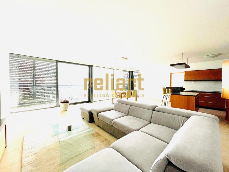 Living room in a 4-room apartment with a comfortable sofa and a kitchenette.