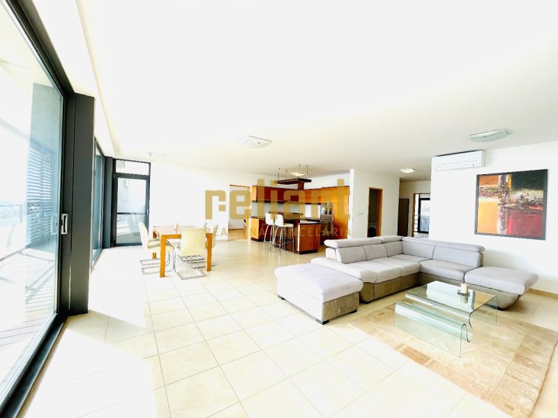 Bright living room in a 4-room apartment with a sofa and a dining table.
