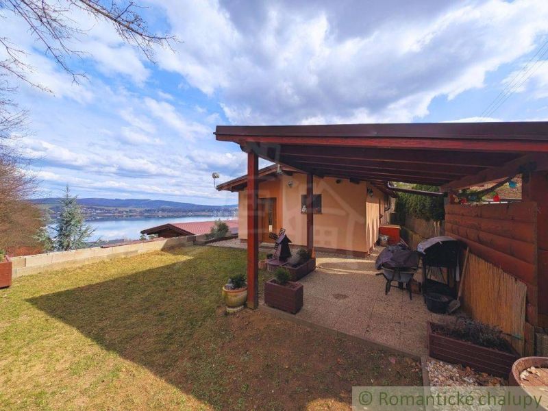 A cottage in Kvakovce with a view of the water surface and a garden terrace.