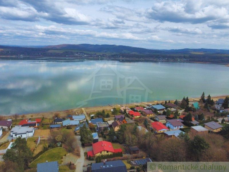 Cottage by the lake in Kvakovce with a panoramic view of the water surface and the sky.