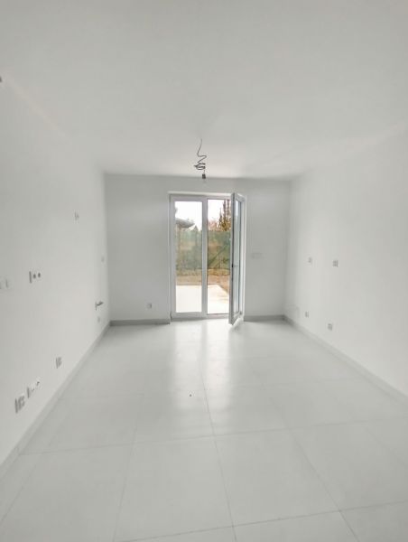 A spacious room with large windows and white walls in a 2-room apartment.