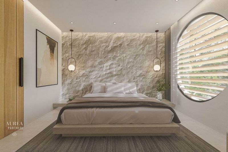 Bedroom in a villa with a textured wall, circular window, and pendant lights.