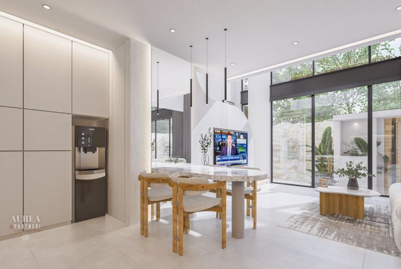 Interior of a villa with an open space, large windows, and a table with chairs.