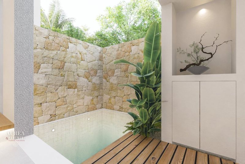 A small pool in an enclosed area of the villa with wooden floor decoration and green plants.