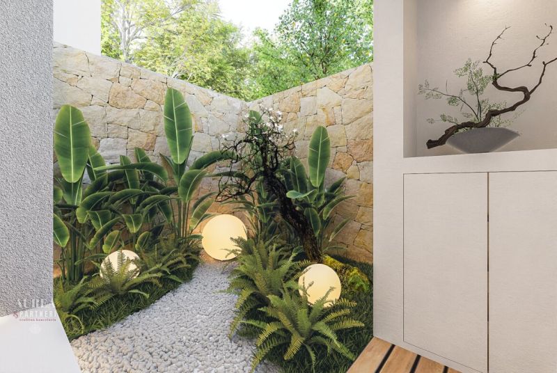 Private garden in a villa with a brick wall, plants, and spherical lamps.