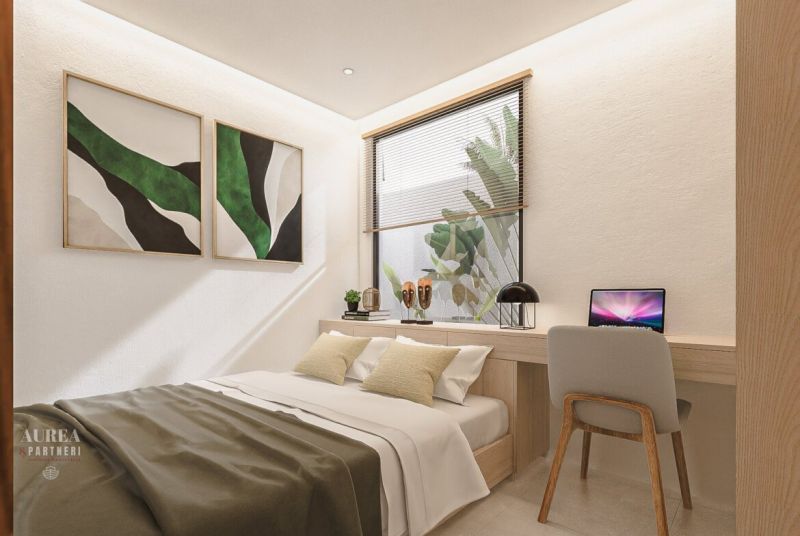 Bedroom in a villa with a bed, wall decorations, and a desk.