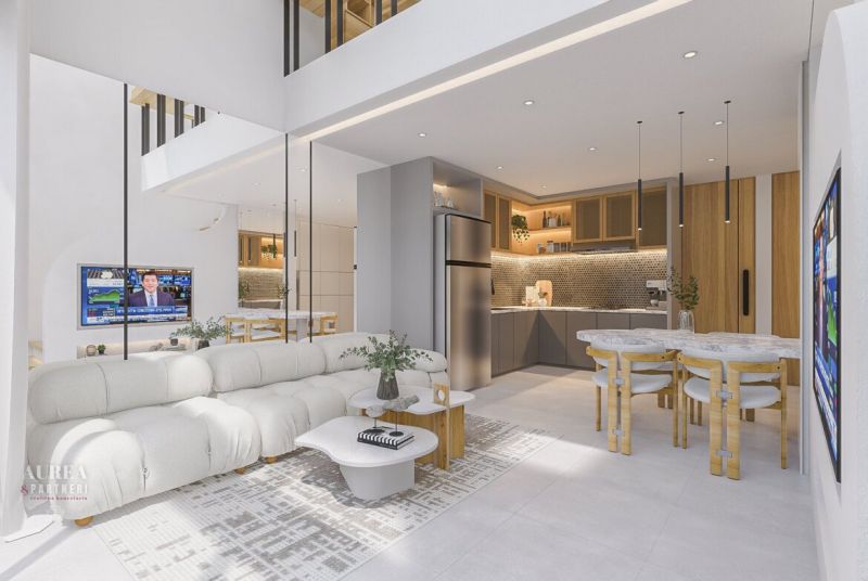 Living room in a villa with a light sofa, kitchen, and dining table.