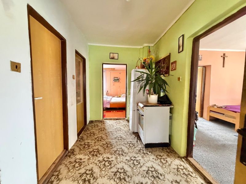 A hallway with carpeted flooring in a family house with entrances to rooms.