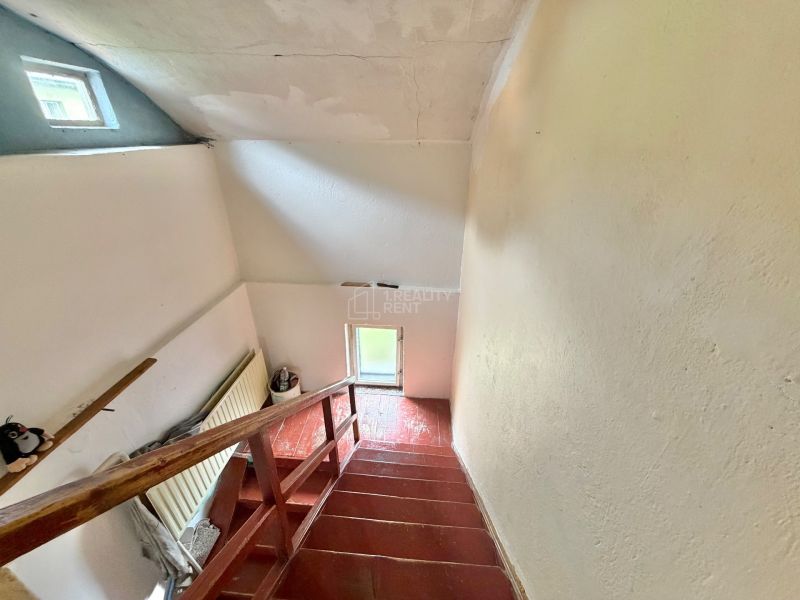 A staircase in a family house with a simple railing and a small window.