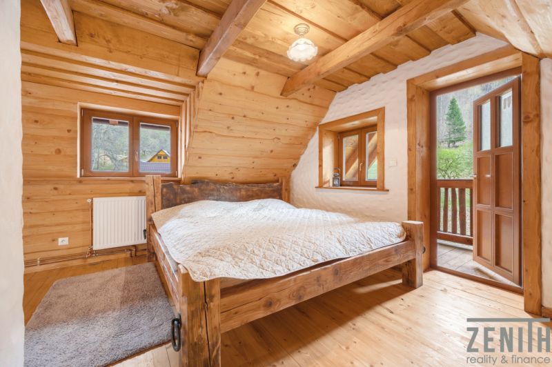 Wooden bedroom in a family house with a view, bed, wooden decor flooring, and a balcony.