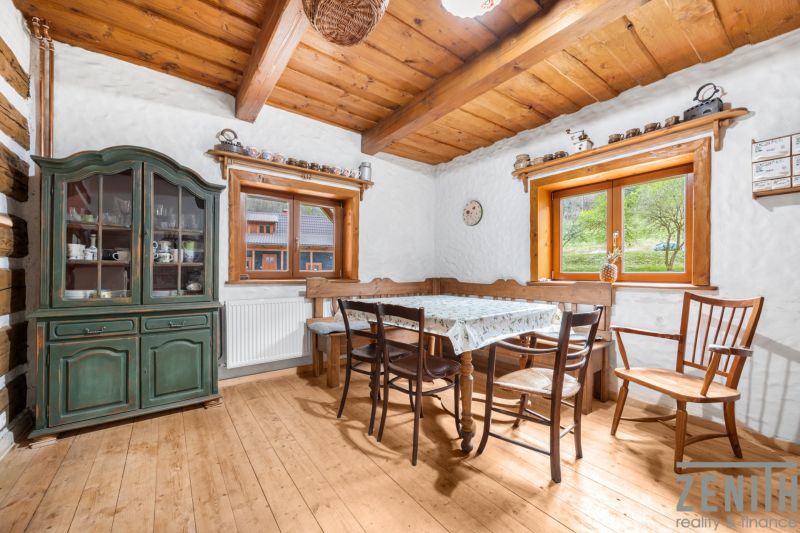 A dining room with a wooden ceiling and a floor with a wooden decor, antique furniture.