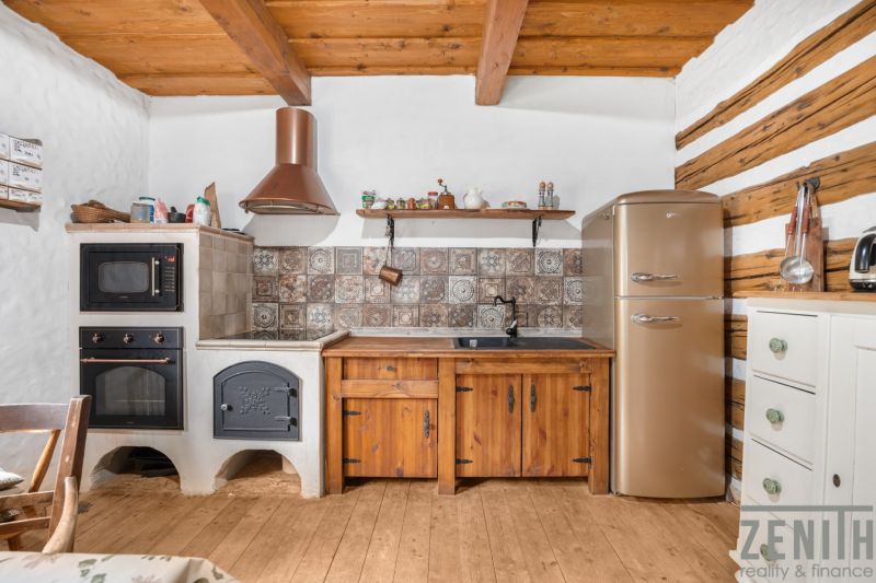 Interior of a family house with a kitchenette, oven, wooden furniture, and a floor with a wooden decor.