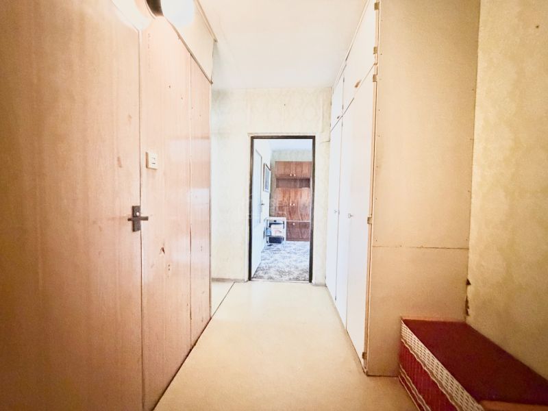 An entrance hall with wooden doors and built-in wardrobes in a 2-room apartment.