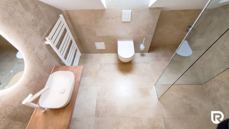 Bathroom with a toilet, shower, sink, and modern flooring with a wood design.