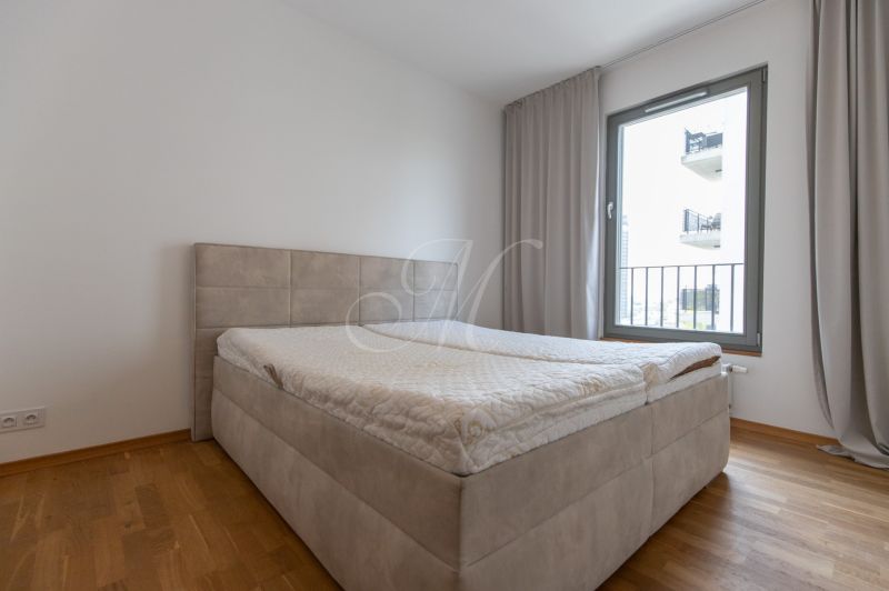 Bedroom in a 3-room apartment with a bed and a wooden decor floor.