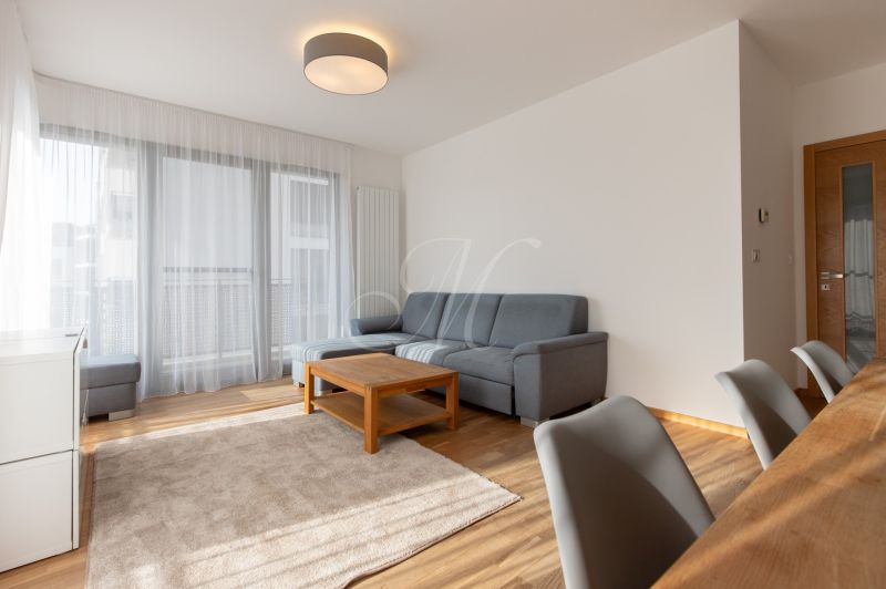 Living room in a 3-room apartment with a corner sofa and a wooden decor floor.