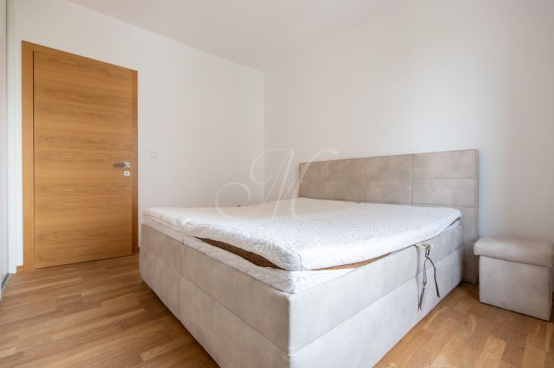 A bedroom with a bed on the floor with wooden decor in a 3-room apartment.