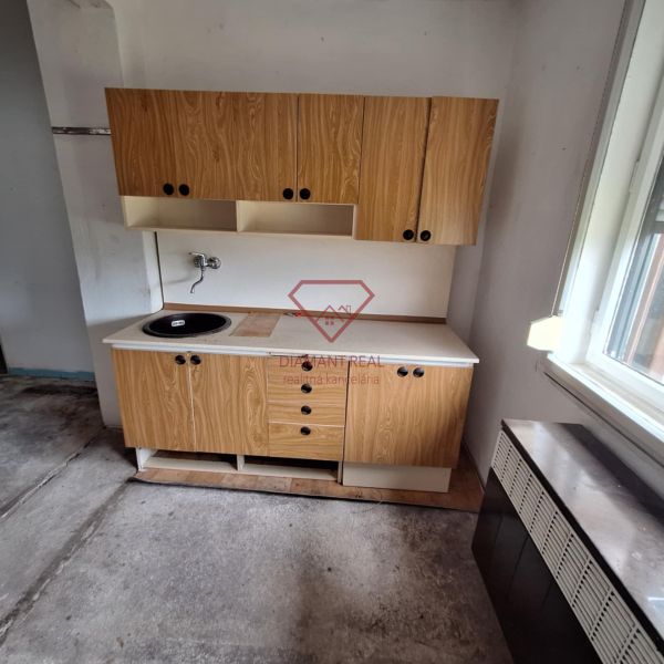 Wooden kitchen unit with a sink in the interior of a family house with low cabinets.