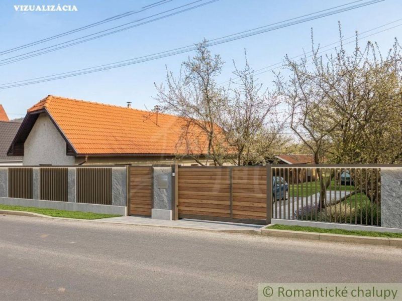 A family house in Stožok with a traditional pitched roof and a wooden gate.