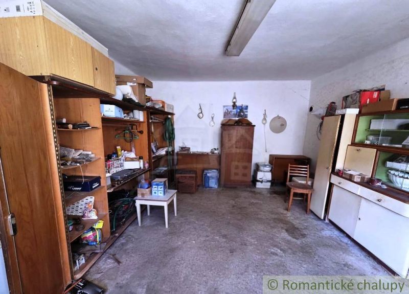 Interior of a cabin with shelves, a cabinet, and a chair, suitable for storing items.