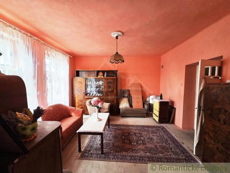 The interior of a family house with orange walls, carpet, and vintage furniture.