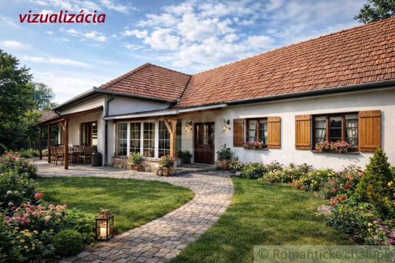 A cottage in Šahy with a flower garden and a paved walkway, surrounded by greenery.