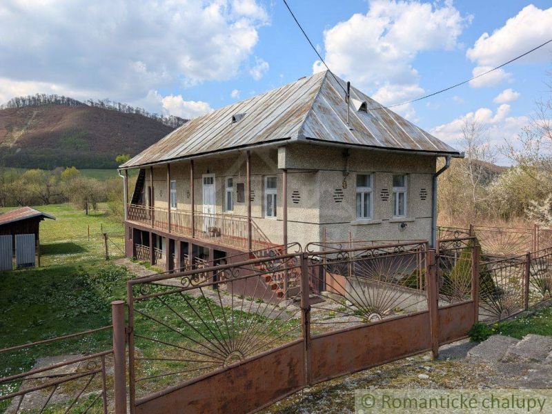 A family house in Zubné with a metal roof, fencing, and a rural surrounding.