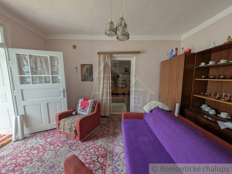 Living room in a family house with carpeted floor and retro furniture.