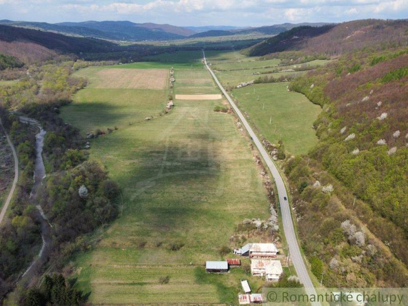 A valley with fields and forests, a road leading to a family house in Zubné.