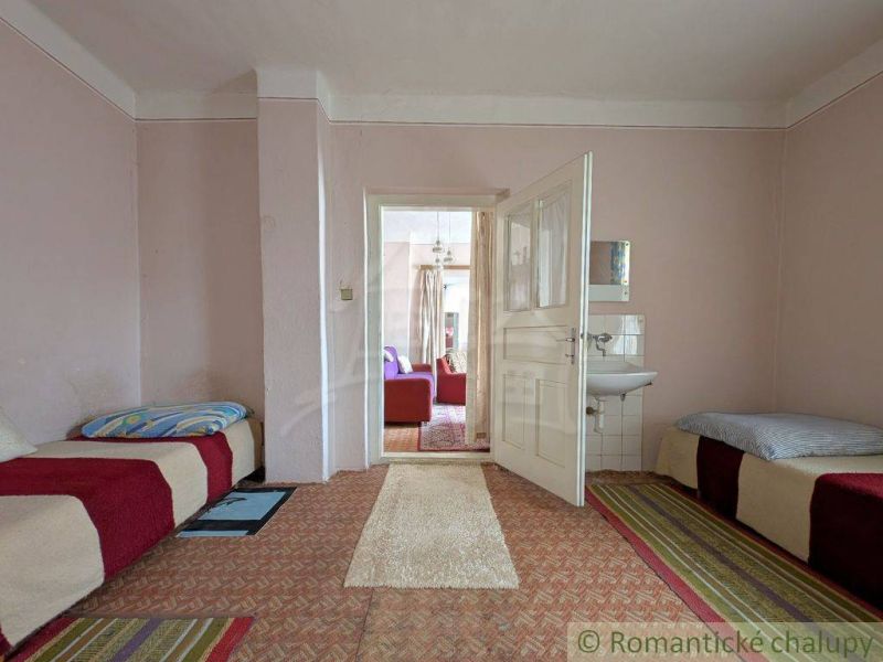 Interior of a family house with an entrance hallway, beds, and a sink.