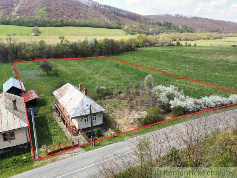 A family house in Zubné with a spacious plot, bordered by a road and trees.