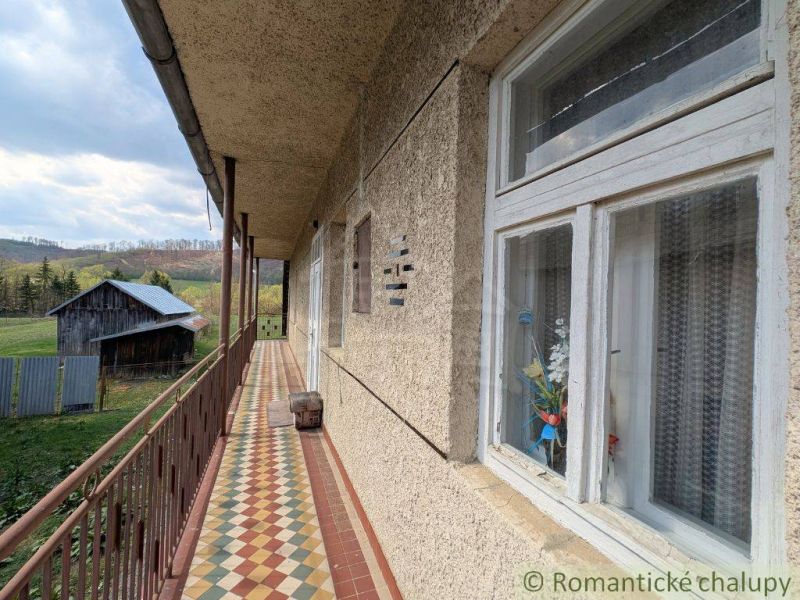 A balcony of a family house in Zubné with a view of wooden buildings and the countryside.