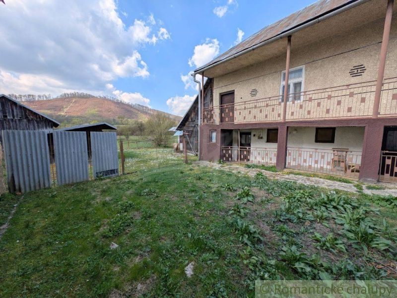 A family house in Zubné with a grassy yard and a view of the hills.