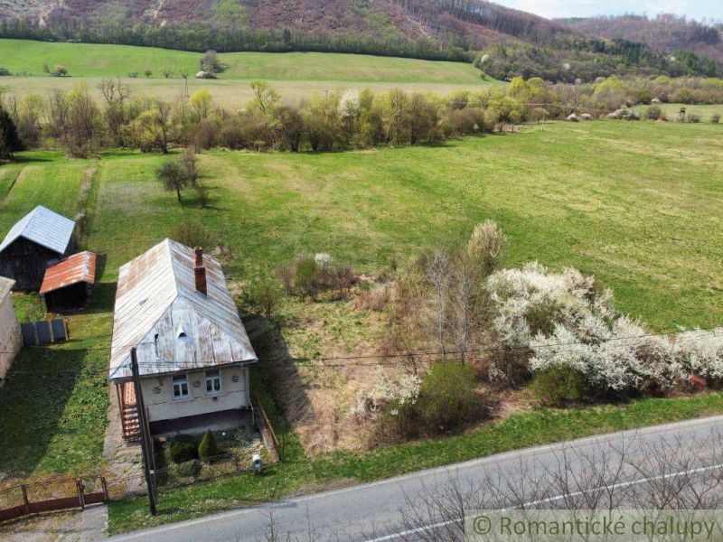 A family house in Zubné surrounded by nature and fields, with a wooden roof.