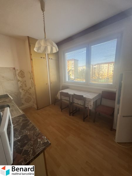 A kitchen in a 3-room apartment with a wooden decor floor, a dining table, and a view.