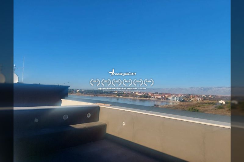 View from a holiday apartment in Privlaka on Privlaka Street by the river and mountains.