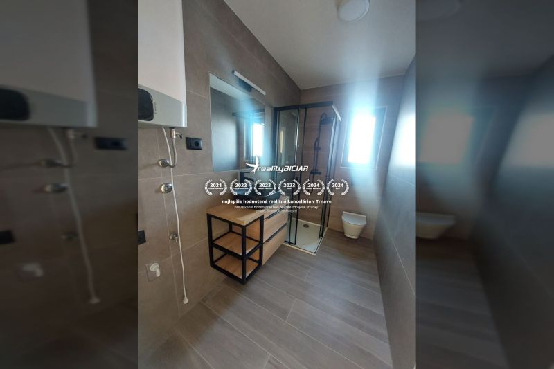 Bathroom in a holiday apartment with wood-patterned flooring and a shower enclosure.