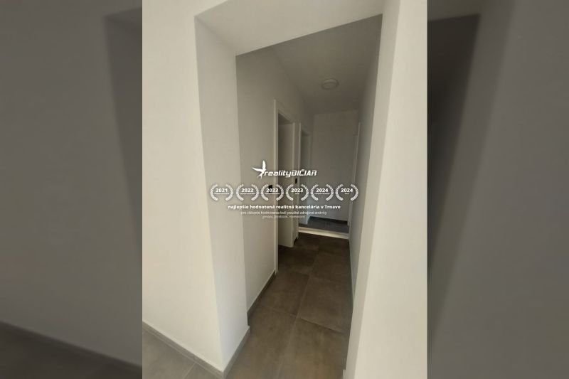 A corridor with tiles and white walls in a holiday apartment.