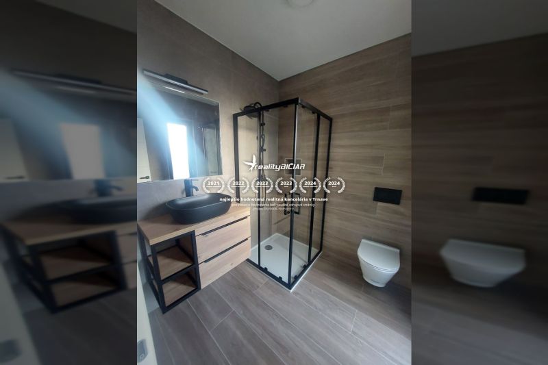 Bathroom in a holiday apartment with a modern shower and wooden decor flooring.