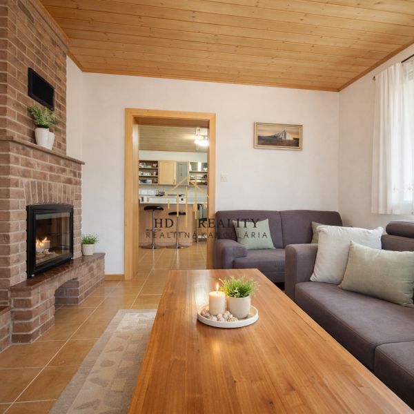 Living room in a family house with a fireplace, sofa, and wooden floor decor.