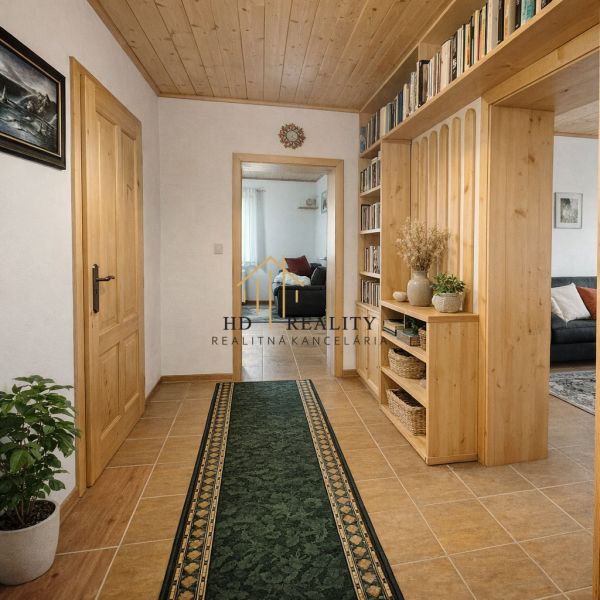 A hallway in a family house with wooden decor and a green carpet, cozy environment.