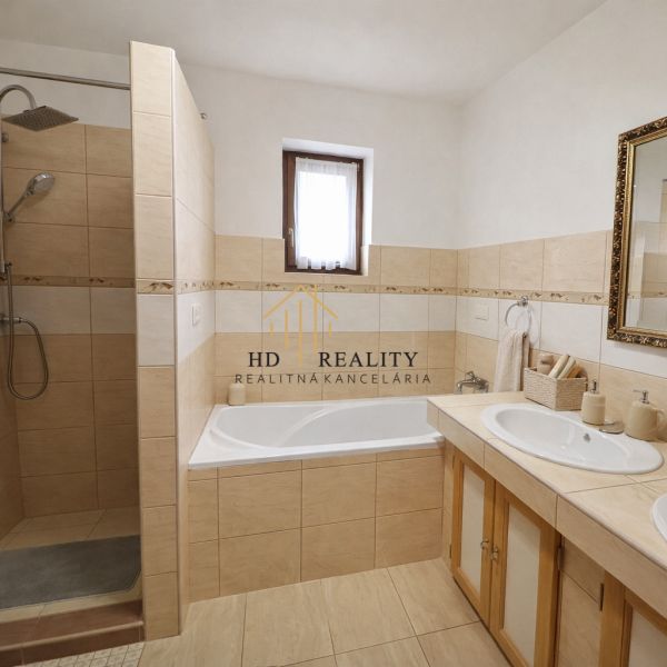 A bathroom in a family house with a bathtub, shower, sink, and window.