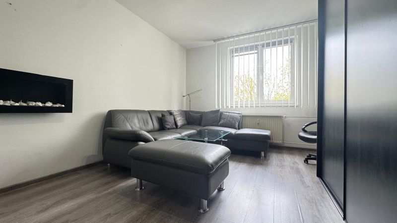 A comfortable view of the living room with a leather sofa set and a wooden decor floor.