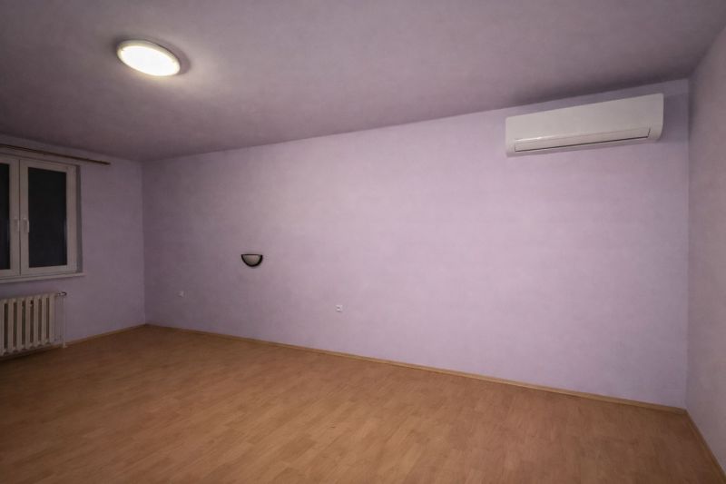 A room with air conditioning and a wooden decor floor in a family house.