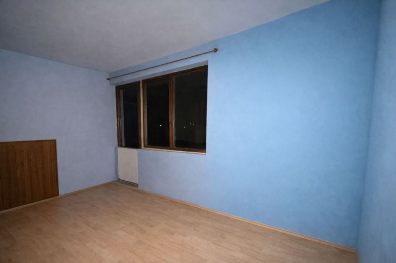 A room in a family house with blue walls and a wooden decor floor.