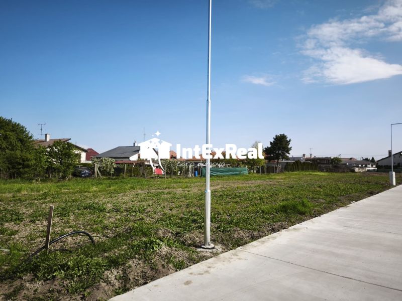 Residential plots in Čierny Brod, green area next to the concrete sidewalk.