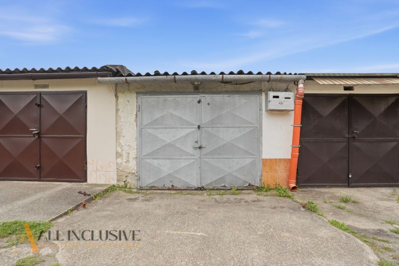 Garages on Hviezdna Street in Komárno with metal doors and a worn facade.